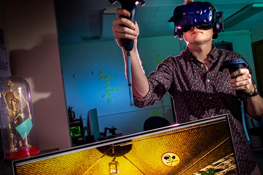 Computer science graduate student and project manager Cameron Merrill explores a virtual cave excavation experience he helped create. 