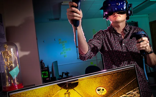 Computer science graduate student and project manager Cameron Merrill explores a virtual cave excavation experience he helped create. 