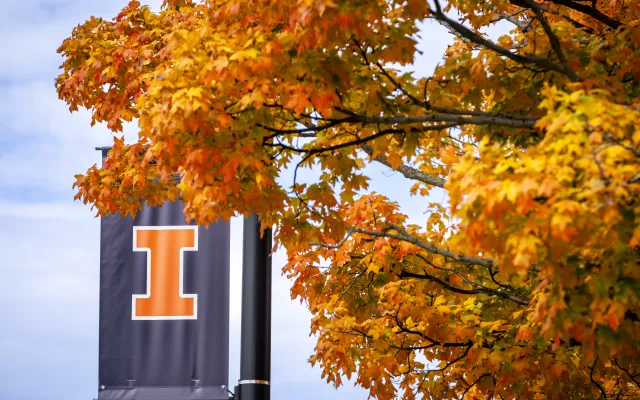 blue block-I street banner against bright orange fall foliage